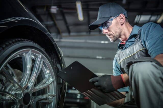 mechanic checking car tires