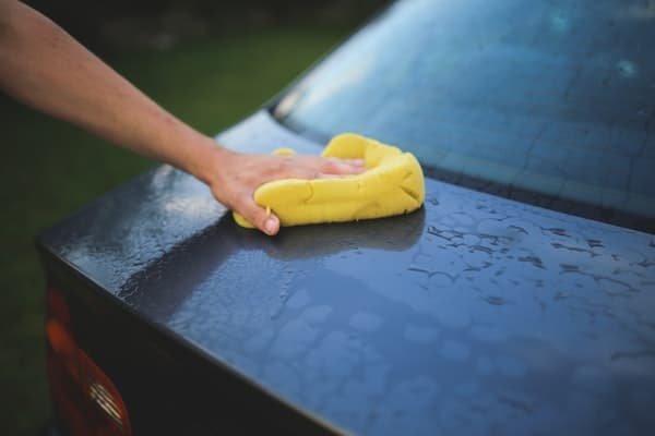 person wiping a car cleaning